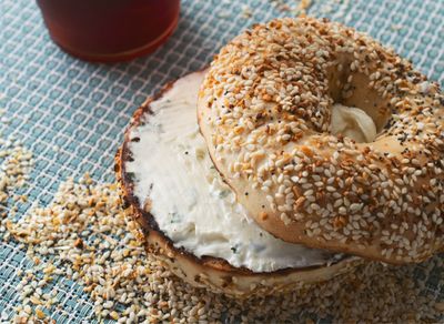 Sesame seed bagel with cream cheese spread across the center